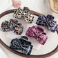 Beau classic bow-shaped claw clip with leopard print on a white background