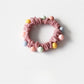 Multiple sweet-colored beaded hair ties displayed in a small transparent container