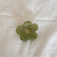 Beau mini flower claw clip clipped onto a fabric for size reference