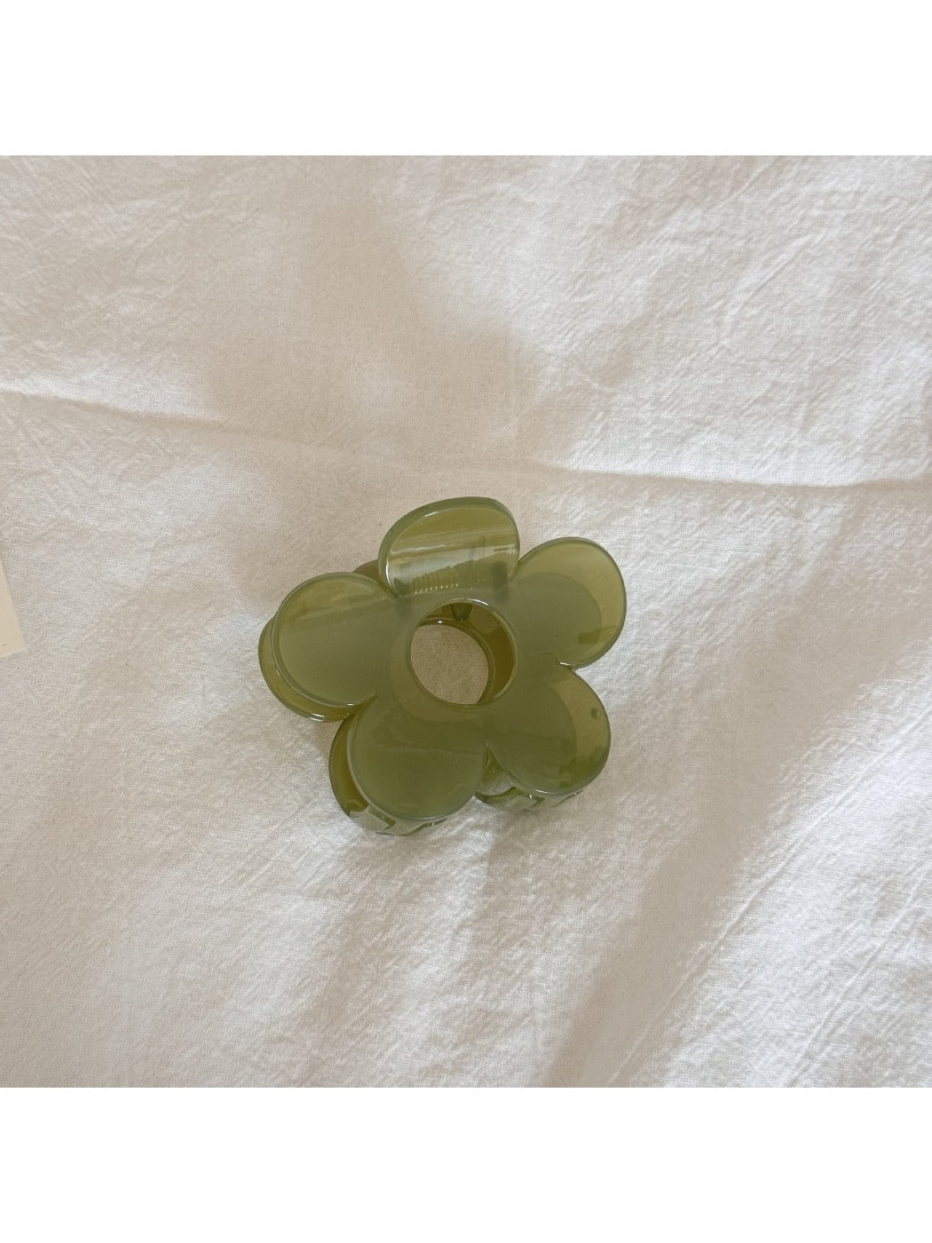 Beau mini flower claw clip clipped onto a fabric for size reference