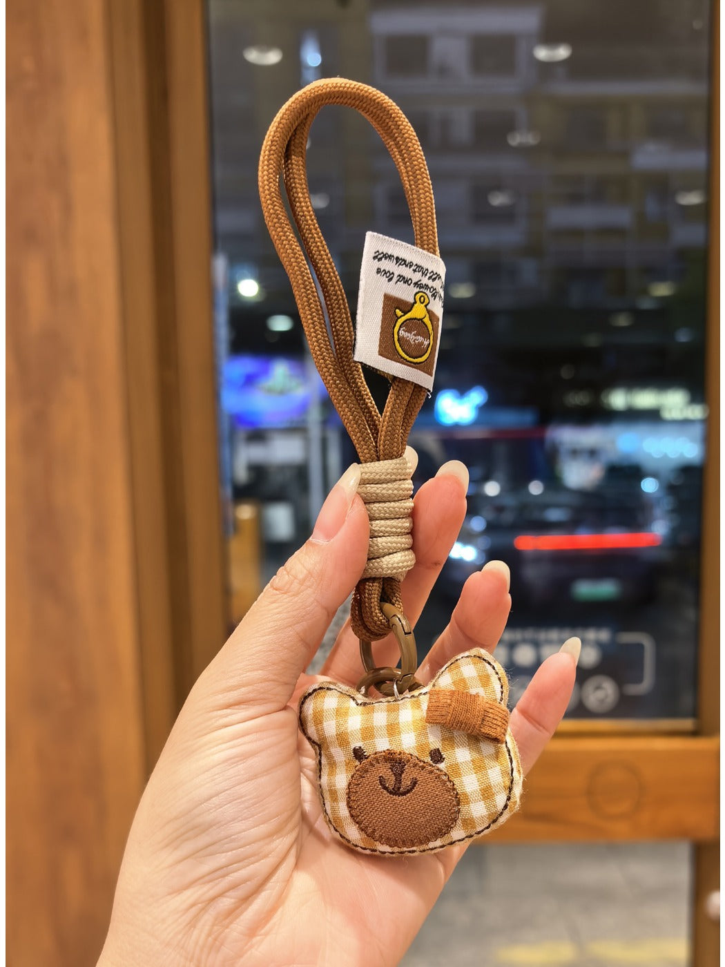 Side view of the bear charm keychain showing its rounded ears and stitched details