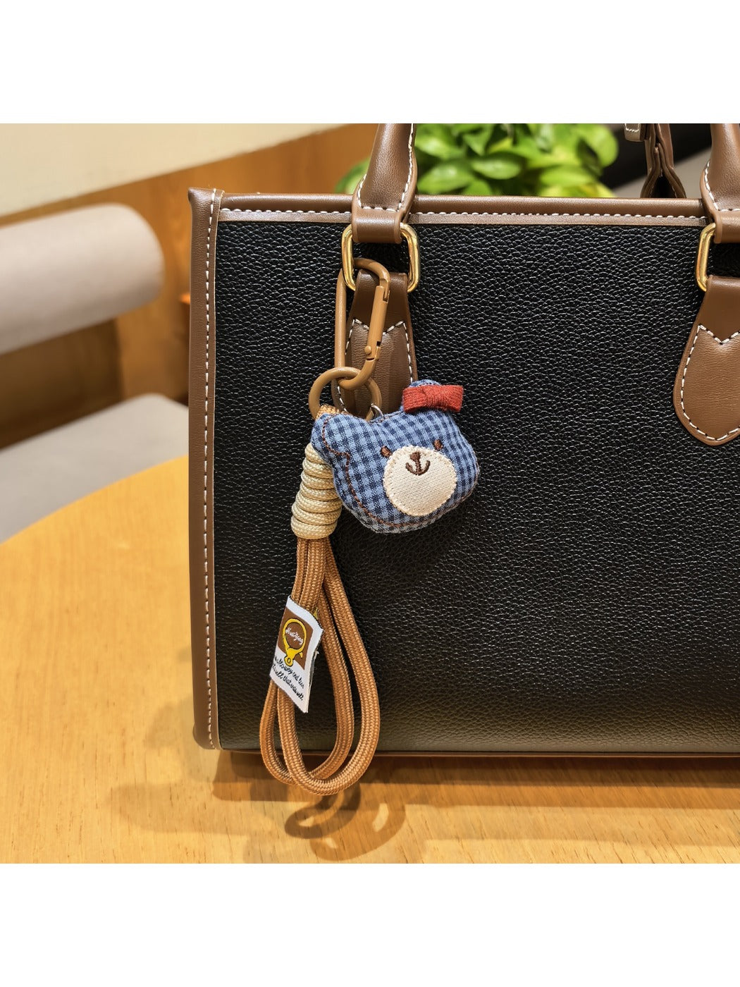 Bear charm keychain next to a smartphone on a desk
