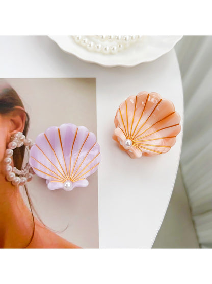 Beau hair claw clip held in hand displaying size and shell design