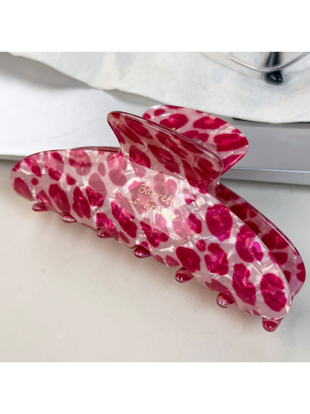 Beau pink leopard print half round claw clip displayed on a model's hair