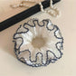 Four tier ruffled scrunchie displayed on a white background