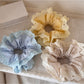 Side view of Gifty lace scrunchie emphasizing its elastic band and gathered lace design