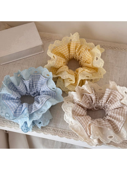 Side view of Gifty lace scrunchie emphasizing its elastic band and gathered lace design
