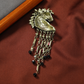 Back of a horse head brooch showing a pin clasp and six hanging strands