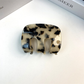 Cream and black mottled letter-detail hair claw, front view