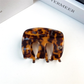 Brown tortoise-pattern letter-detail hair claw, front view