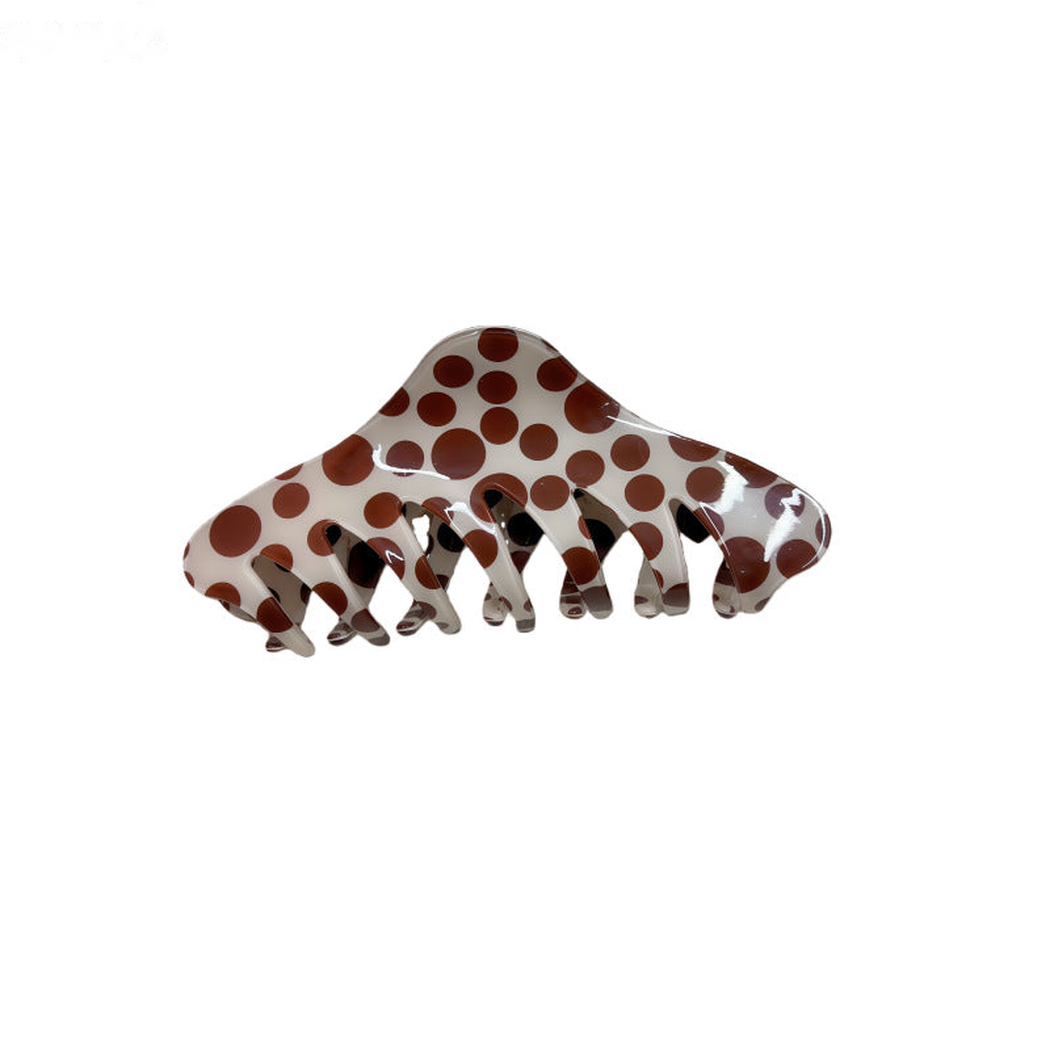Polka dot spine-shaped hair claw clip on white background