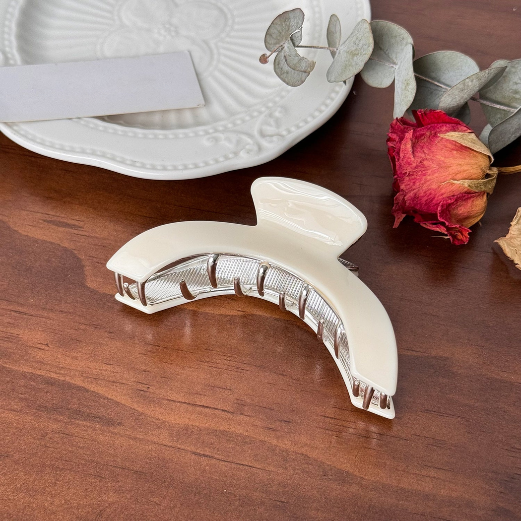 Ivory crescent-shaped hair claw, side view