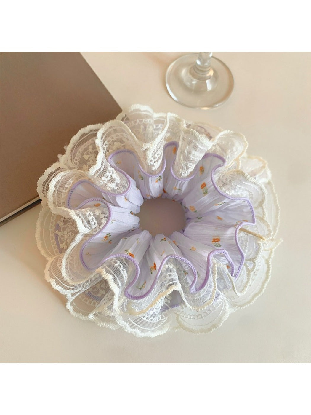 Purple ruched scrunchie displayed on a white background showing texture