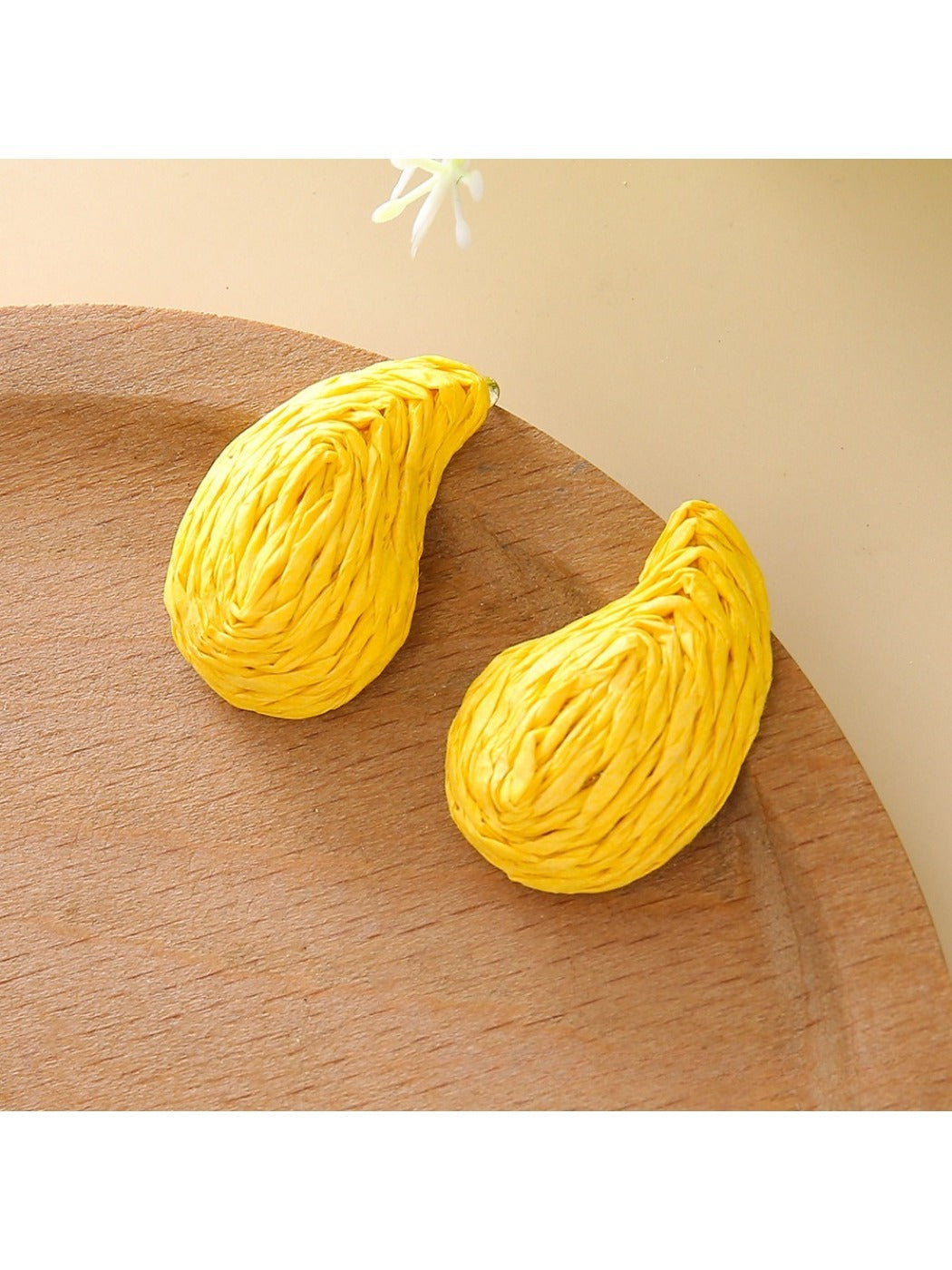 Close-up of the back of raffia water drop shaped stud earrings showing posts
