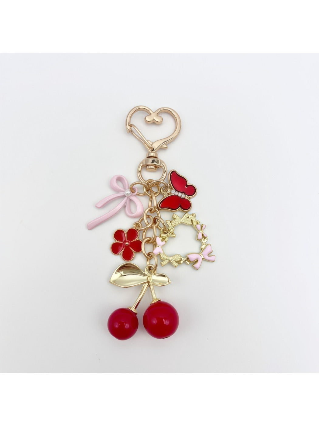 Cherry bow charm keychain attached to a set of keys with a blurred background