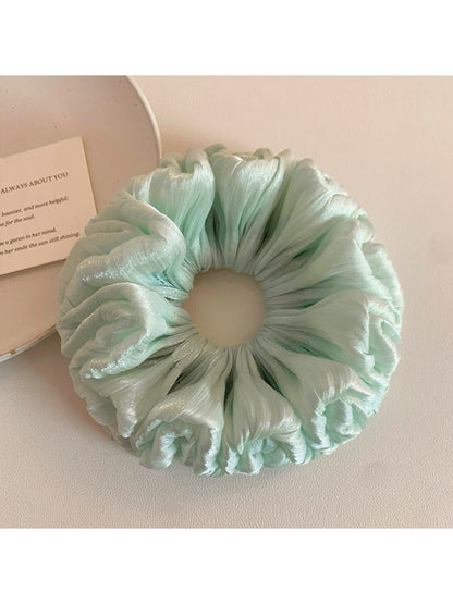 Green double layered scrunchie folded to show layers and elasticity