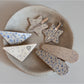 Beau hair clip held in hand displaying size and triangular shape with star print