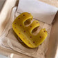 Close-up of yellow Beau claw clip showing curved teeth and polka dot pattern