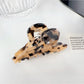 Beau colorful floral hair claw clip featured in lifestyle setting with plants