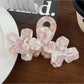 Beau floral hair claw clip worn in a half-up hairstyle on model with dark hair