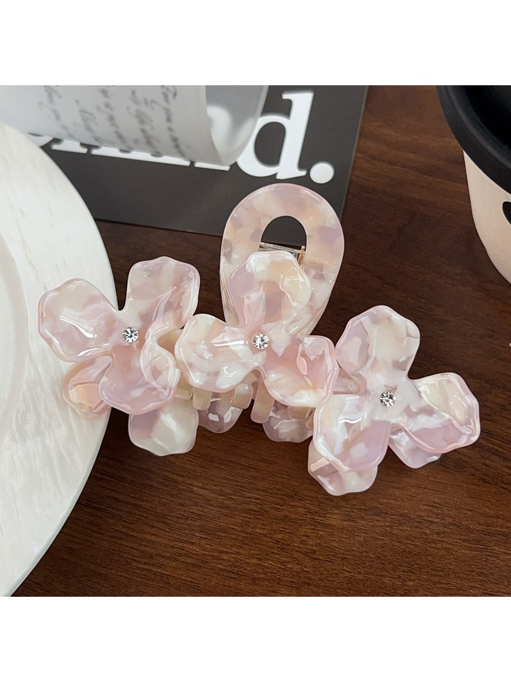 Beau floral hair claw clip worn in a half-up hairstyle on model with dark hair
