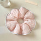 Pink striped hair scrunchie wrapped around a ponytail