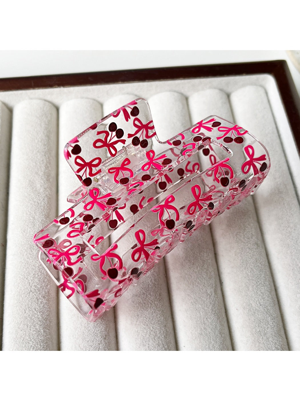 Clear acetate claw clip held in hand, showing size and design