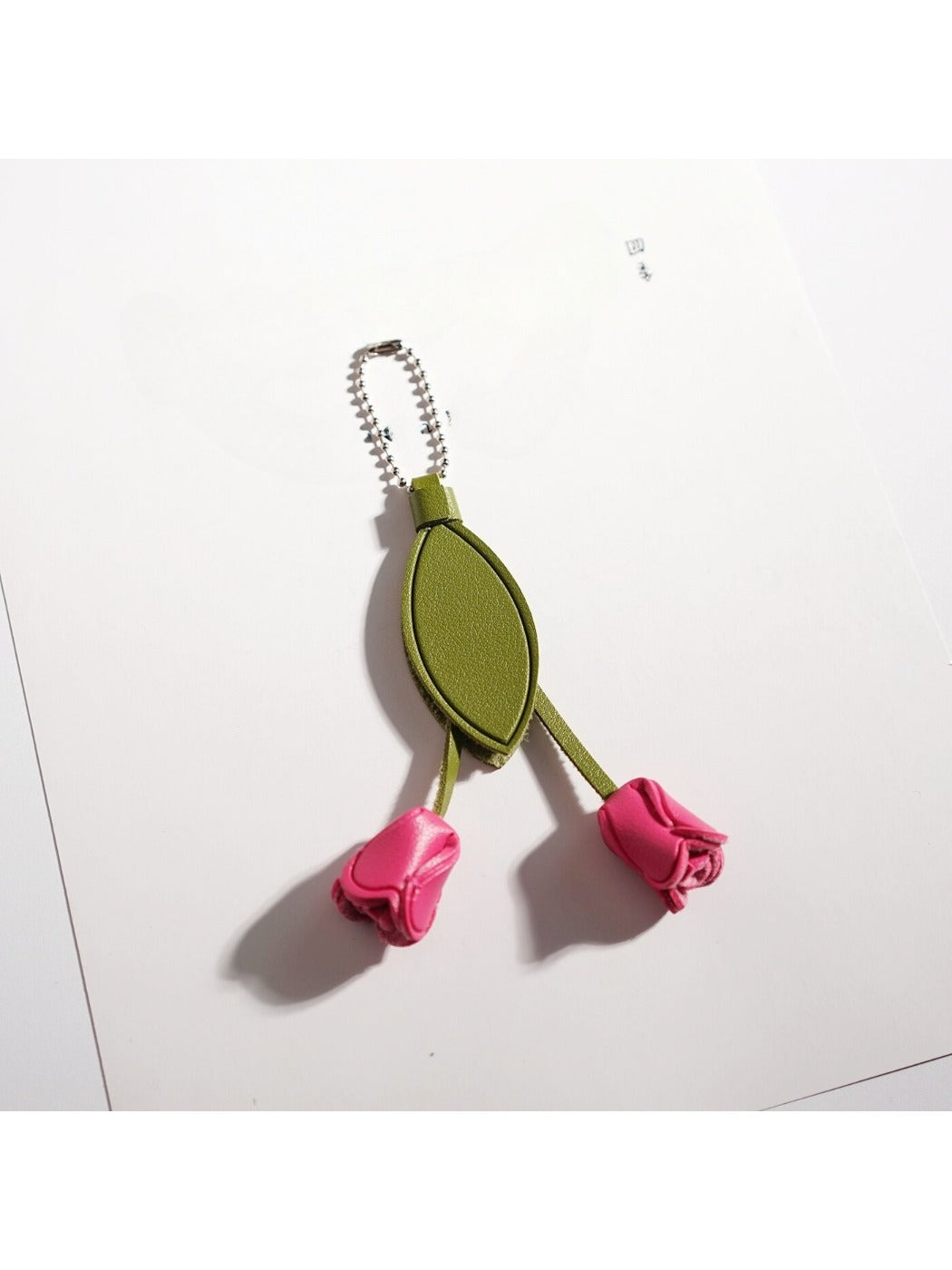 Top view of the tulip keychain highlighting the green stem and leaves