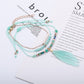 Lovra bracelet with small silver beads and feather pendant shown on hand