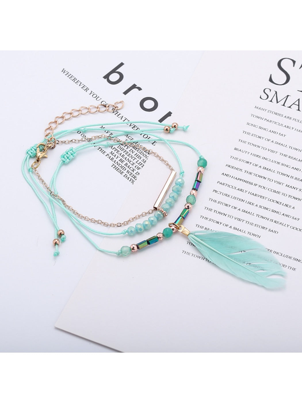 Lovra bracelet with small silver beads and feather pendant shown on hand