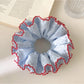 Gifty chic polka dot ruffle scrunchie in black and white on a white background