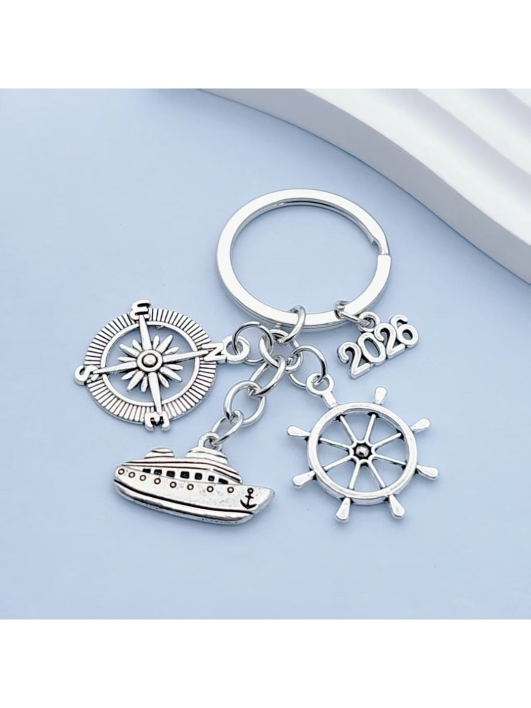 Side view of silver alloy steamship keychain showing hull and portholes