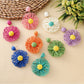 Close-up of raffia sunflower shaped earring with yellow petals and brown center