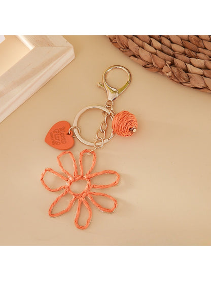 Top view of hollow flower shaped raffia keychain showing detailed weaving