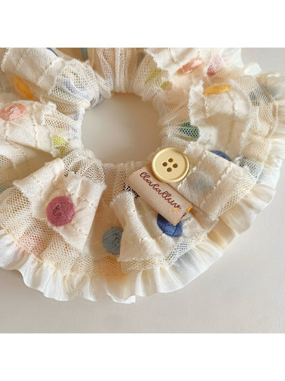 Scrunchie worn on wrist featuring vibrant multicolor polka dots