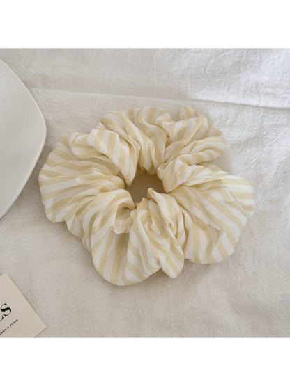 Close-up of yellow striped scrunchie fabric texture and elastic band