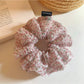 Pink floral print tulle scrunchie on a white background