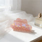 Beau holographic claw clip held in hand showing size and shine