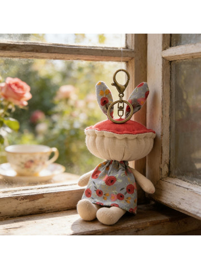 Keypus fabric doll keychain attached to a handbag zipper pull