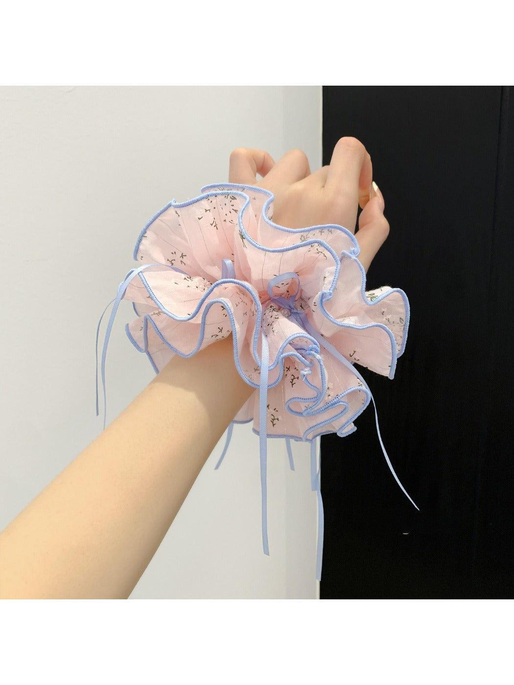 Pink bow print scrunchie wrapped around a ponytail on a model