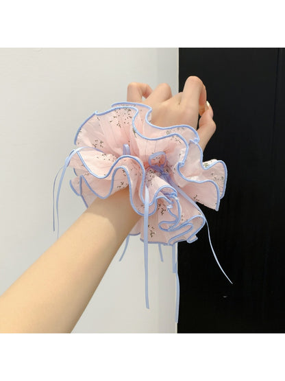 Pink bow print scrunchie wrapped around a ponytail on a model