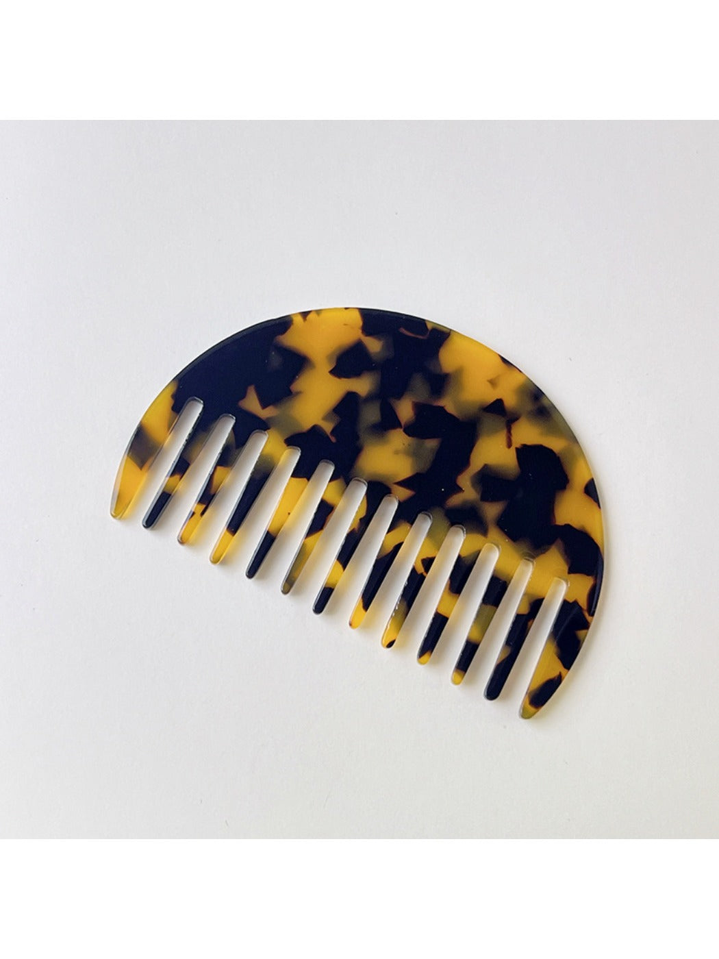 Camerow acetate hair comb with light reflecting off polished surface