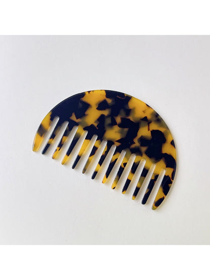 Camerow acetate hair comb with light reflecting off polished surface