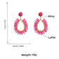 Pair of minimalist oval raffia drop earrings displayed on a beige fabric surface