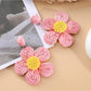Earedge flower shaped drop earrings hanging from a jewelry stand