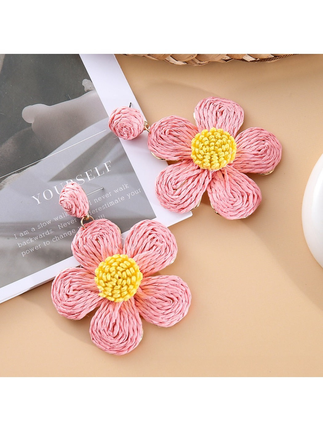 Earedge flower shaped drop earrings hanging from a jewelry stand