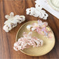 Beau sweet chic flower shaped claw clip in soft pink on white background