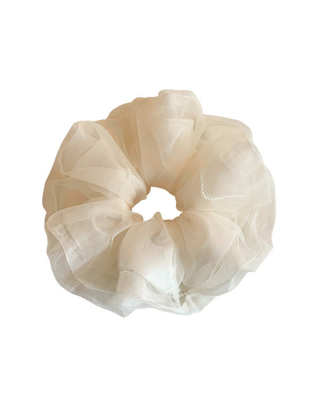 Beige tulle scrunchie wrapped around a ponytail in soft natural light