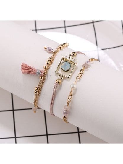 Lovra bracelet with gold tassel pendant and small round beads in natural light