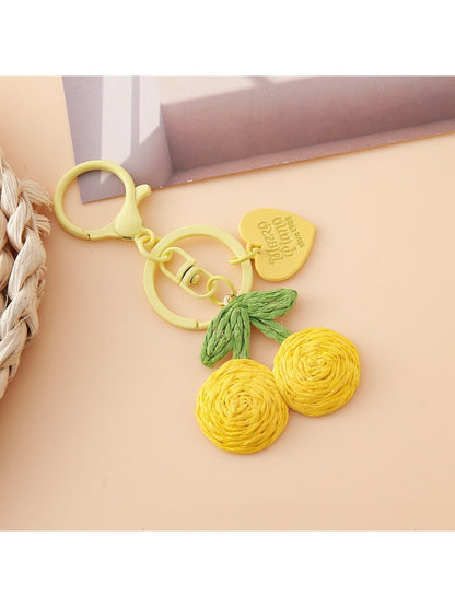 Hand holding the Keypus cherry charm keychain showing its size and details